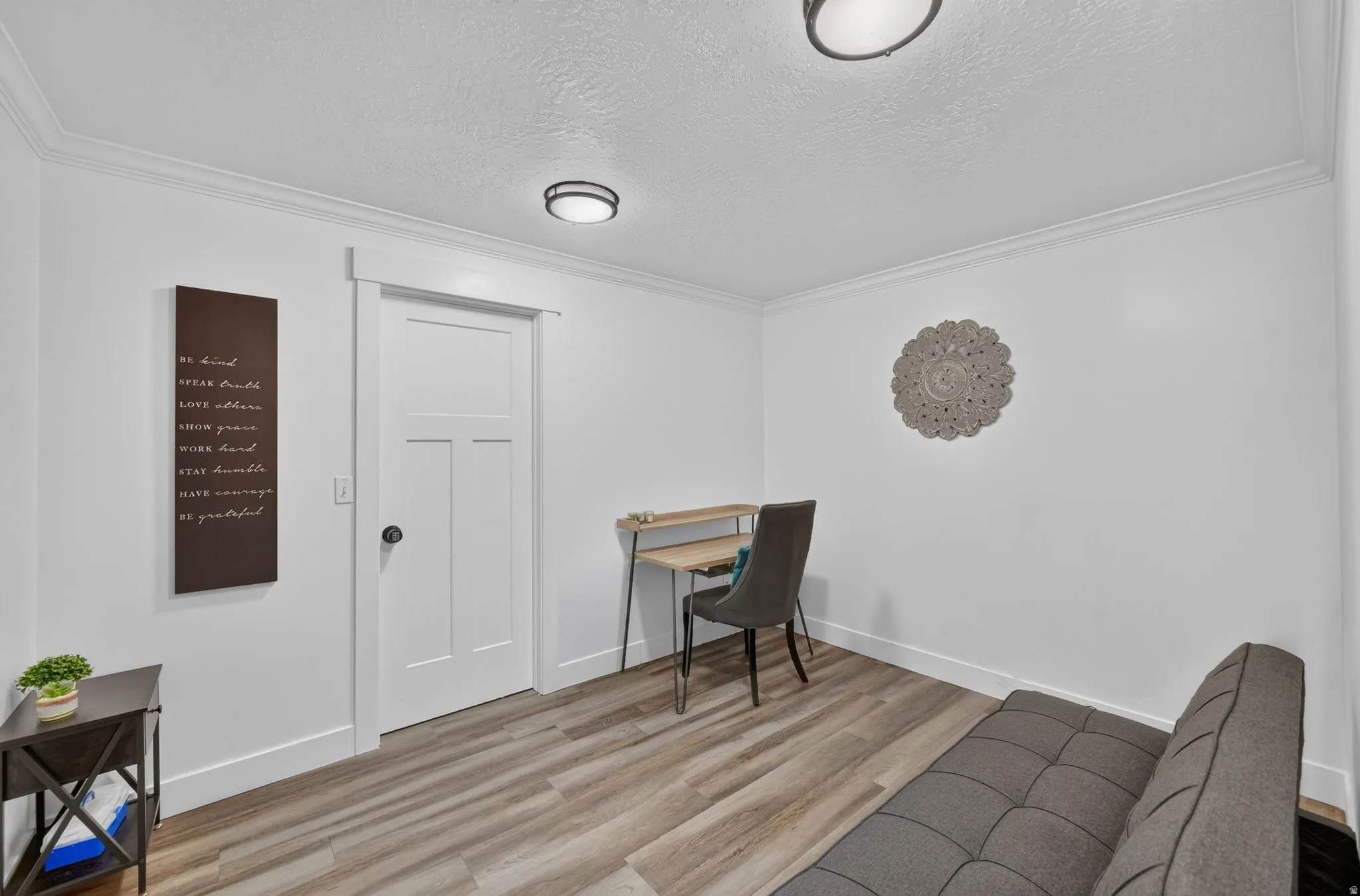 Wood-finish flooring, white walls, and crown molding