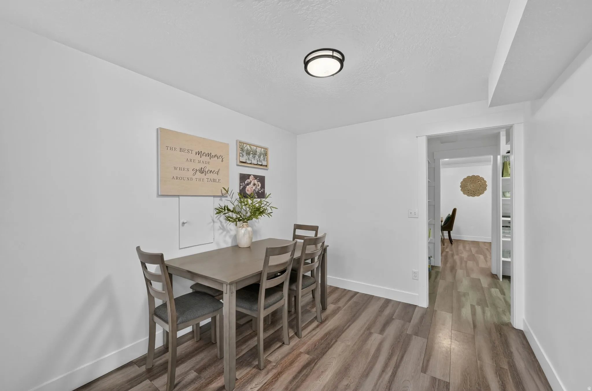 Wood-finish flooring throughout, bright white walls, and a recessed ceiling light fixture