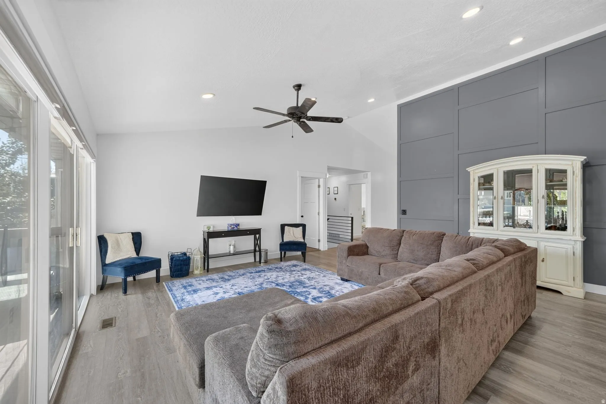 Vaulted ceiling with a ceiling fan, recessed lighting, and wood-finish flooring