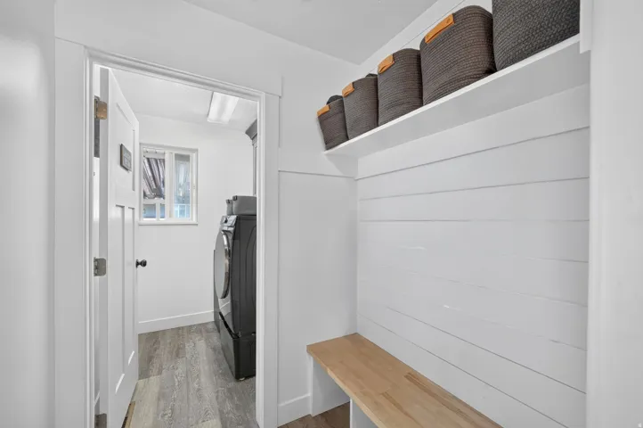 Entryway featuring a built-in bench, shiplap wall detail, and a storage shelf