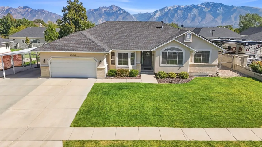 Single-story residence featuring a two-car garage, manicured lawn, and a paved driveway