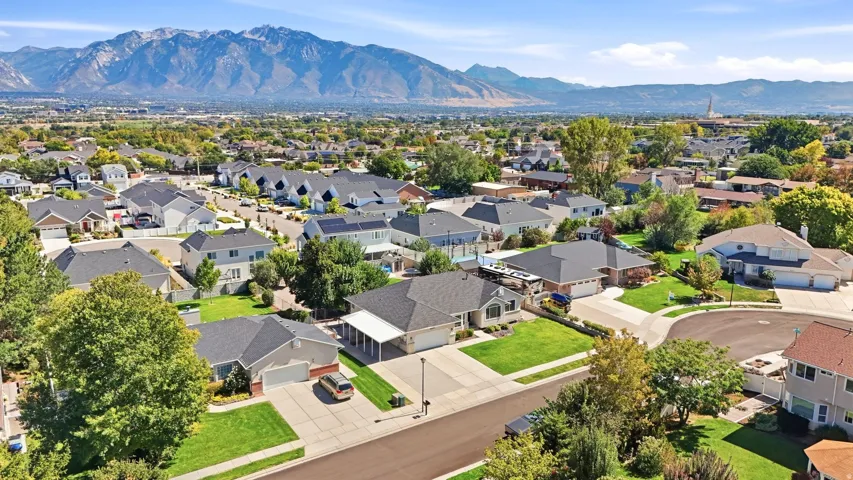 Residential neighborhood with a mountain backdrop, mature landscaping, and varied architectural styles