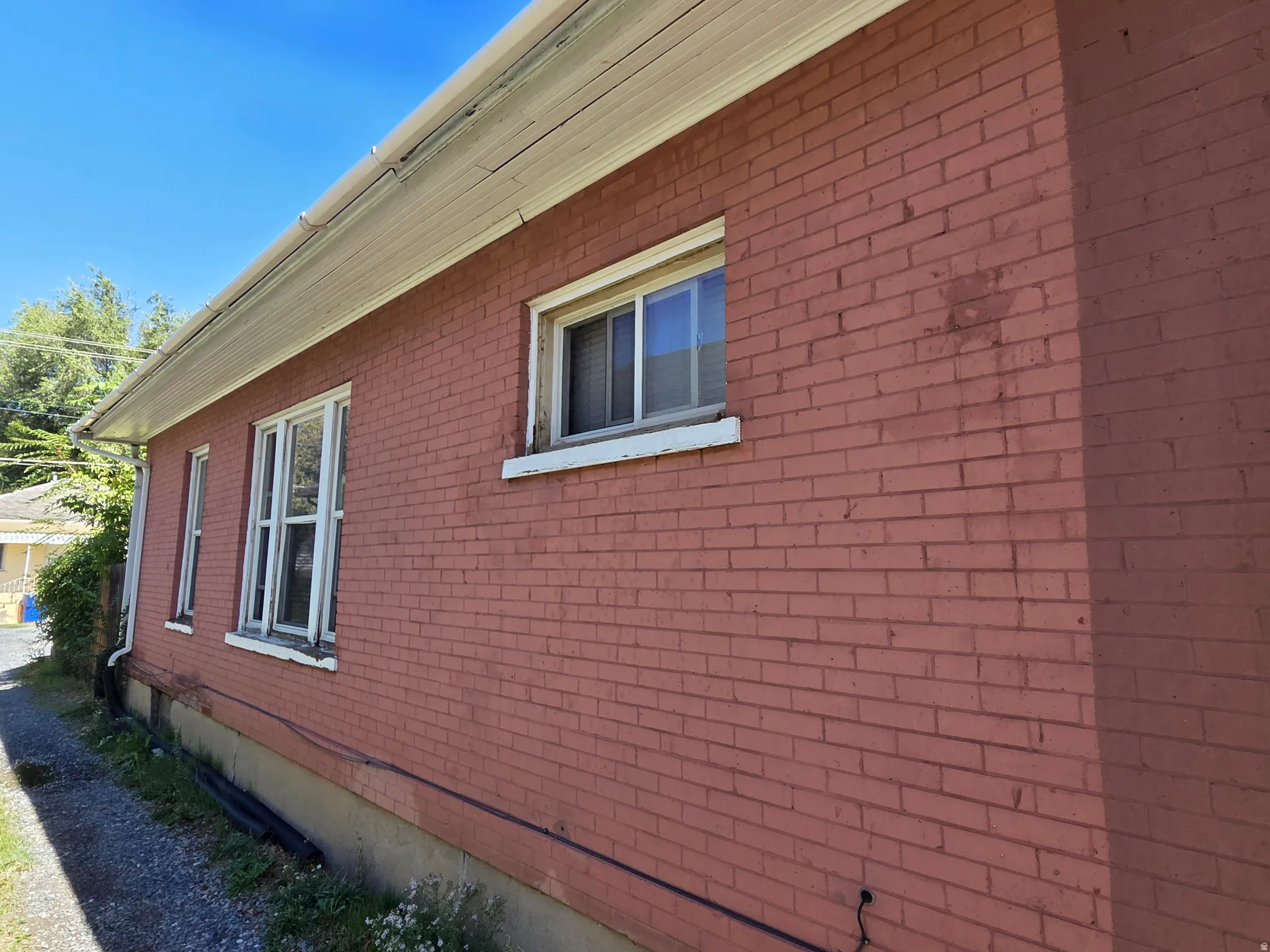 Brick exterior with white window frames and a white soffit