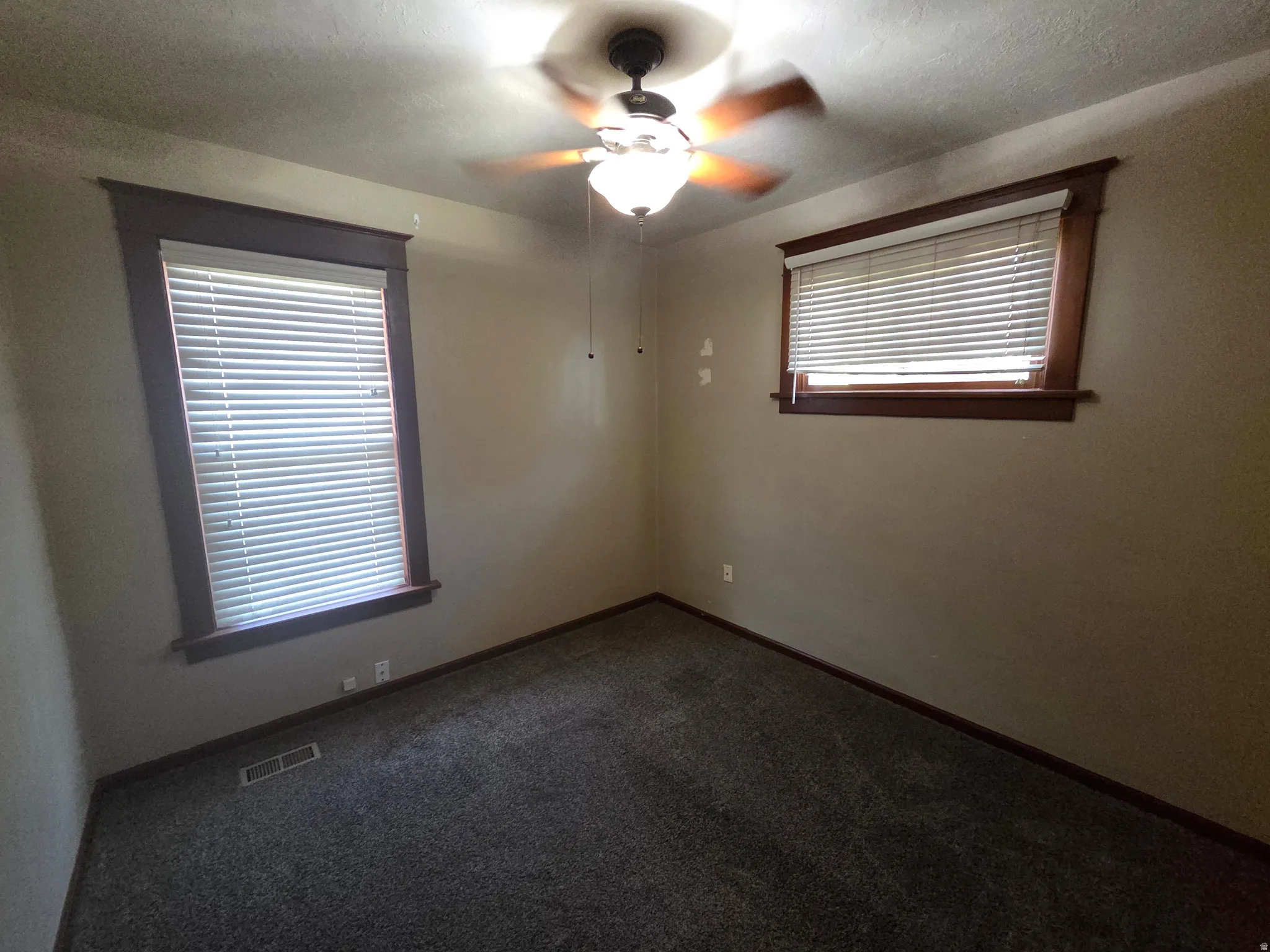 Recessed lighting, ceiling fan, two windows with blinds, wood-finish window trim, and wall-to-wall carpeting