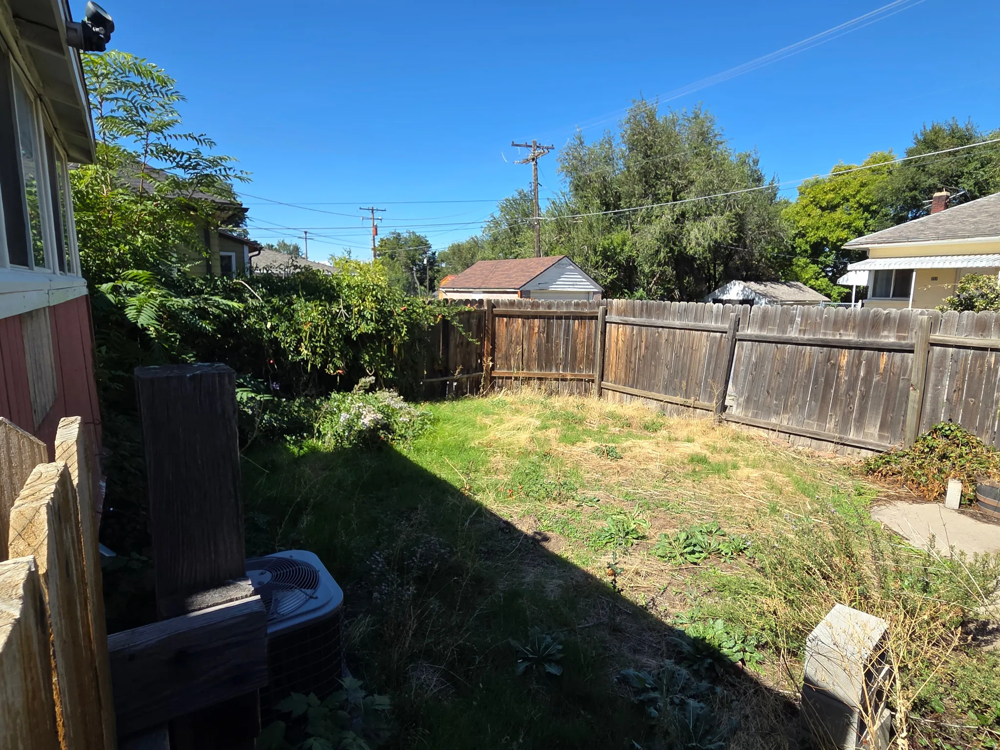 Enclosed backyard with a wood privacy fence and a grassy area