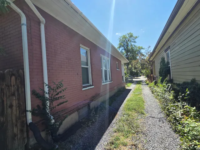 Brick exterior with white downspouts and a gravel path