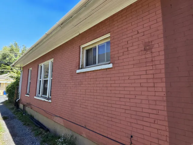 Brick exterior with white window frames and a white soffit