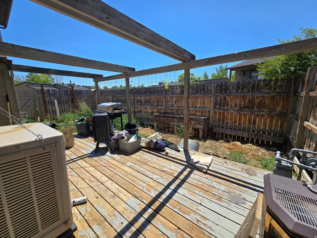 Wood-finish deck with open pergola framework and privacy fencing