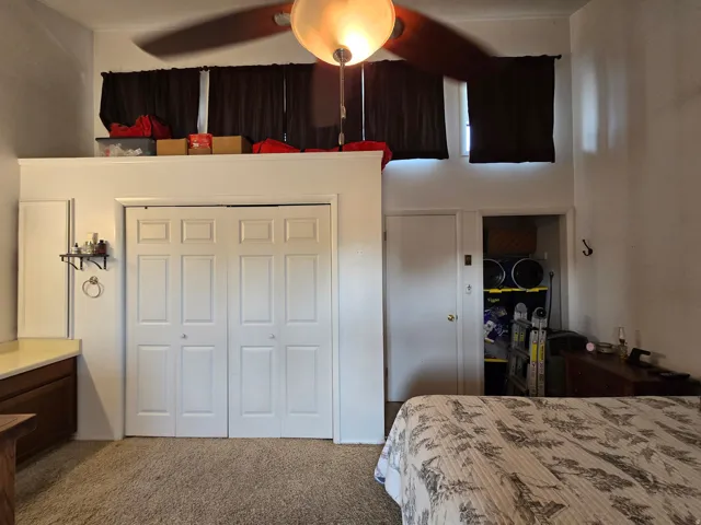 Vaulted ceilings with ceiling fan, bi-fold closet doors, additional built-in storage, and wall-mounted shelving