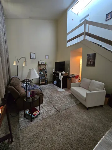 Living area featuring a vaulted ceiling, lofted space, and built-in staircase