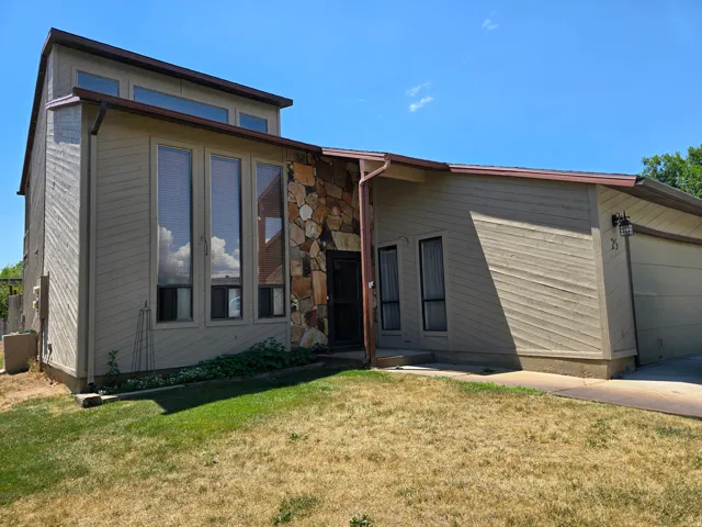 Exterior featuring a stone facade accent, large vertical windows, and sloped roofline