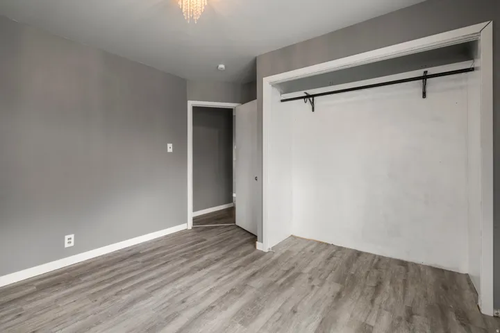 Gray painted walls, wood-finish flooring, recessed lighting, and a built-in closet with a hanging rod