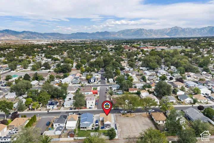 Expansive neighborhood setting with mature trees and mountain backdrops