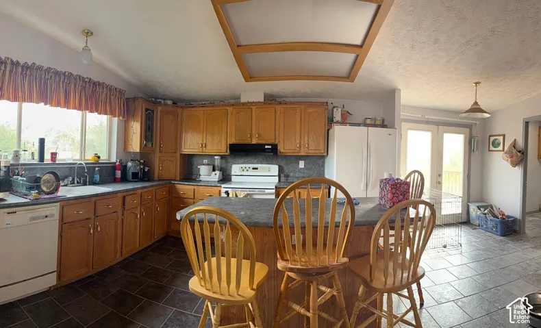 Corner kitchen with wood-finish cabinetry, a central island, and tiled flooring