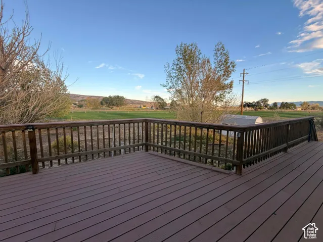 Expansive composite deck with horizontal wood-finish decking and black aluminum railing system overlooking open countryside