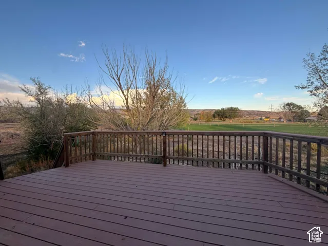 Spacious outdoor deck with composite decking, dark wood railing, and expansive outdoor scenery