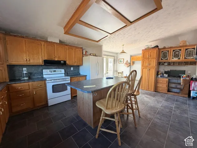 Spacious kitchen featuring wood cabinetry,  and a tile-finish countertop island with seating