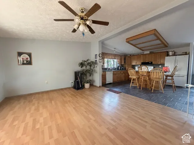 Open concept living space featuring wood-finish flooring and a ceiling fan
