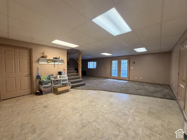 Spacious finished basement with neutral tile flooring, recessed ceiling lighting, and skylight providing natural illumination