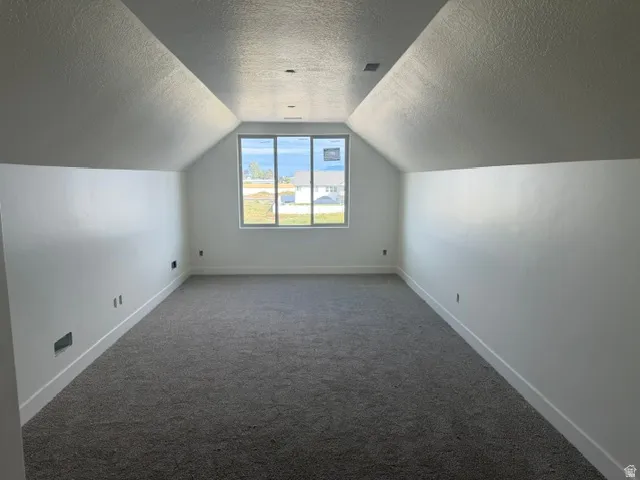 Recessed lighting, sloped ceilings, wall-to-wall carpeting, and a large multi-pane window