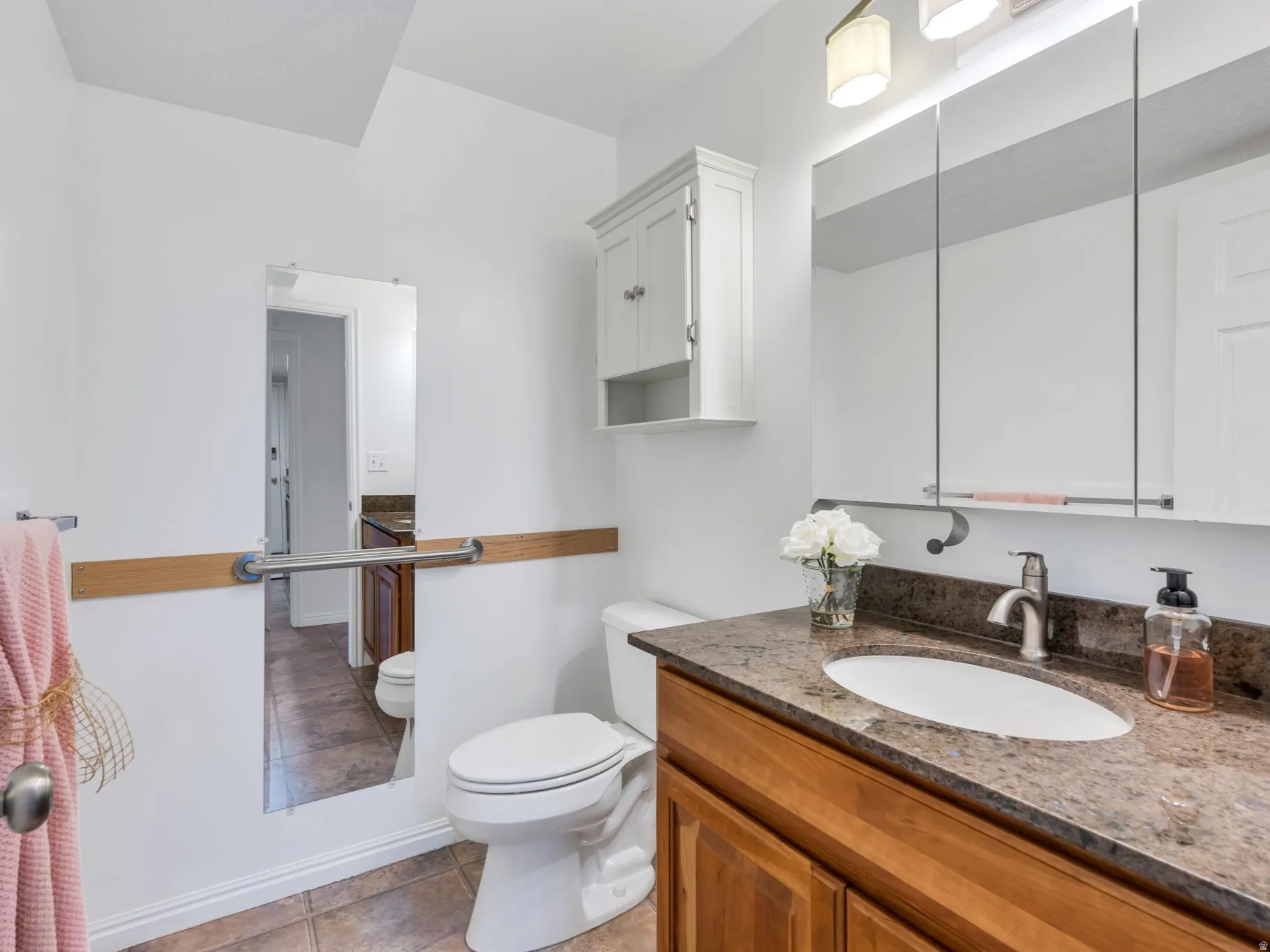 Main Floor Half Bath, Warm wood-finish vanity with a dark speckled countertop