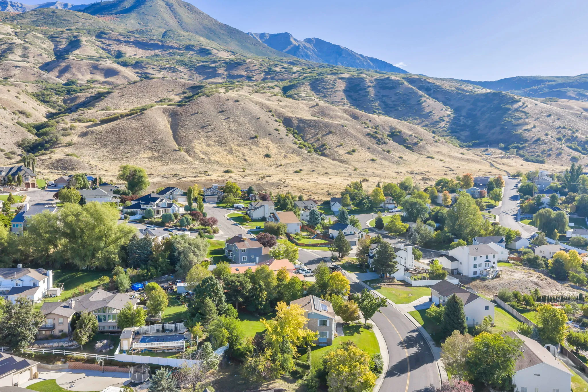 Upper East Side of Lindon with Mountain backdrop, mature trees, and paved roads
