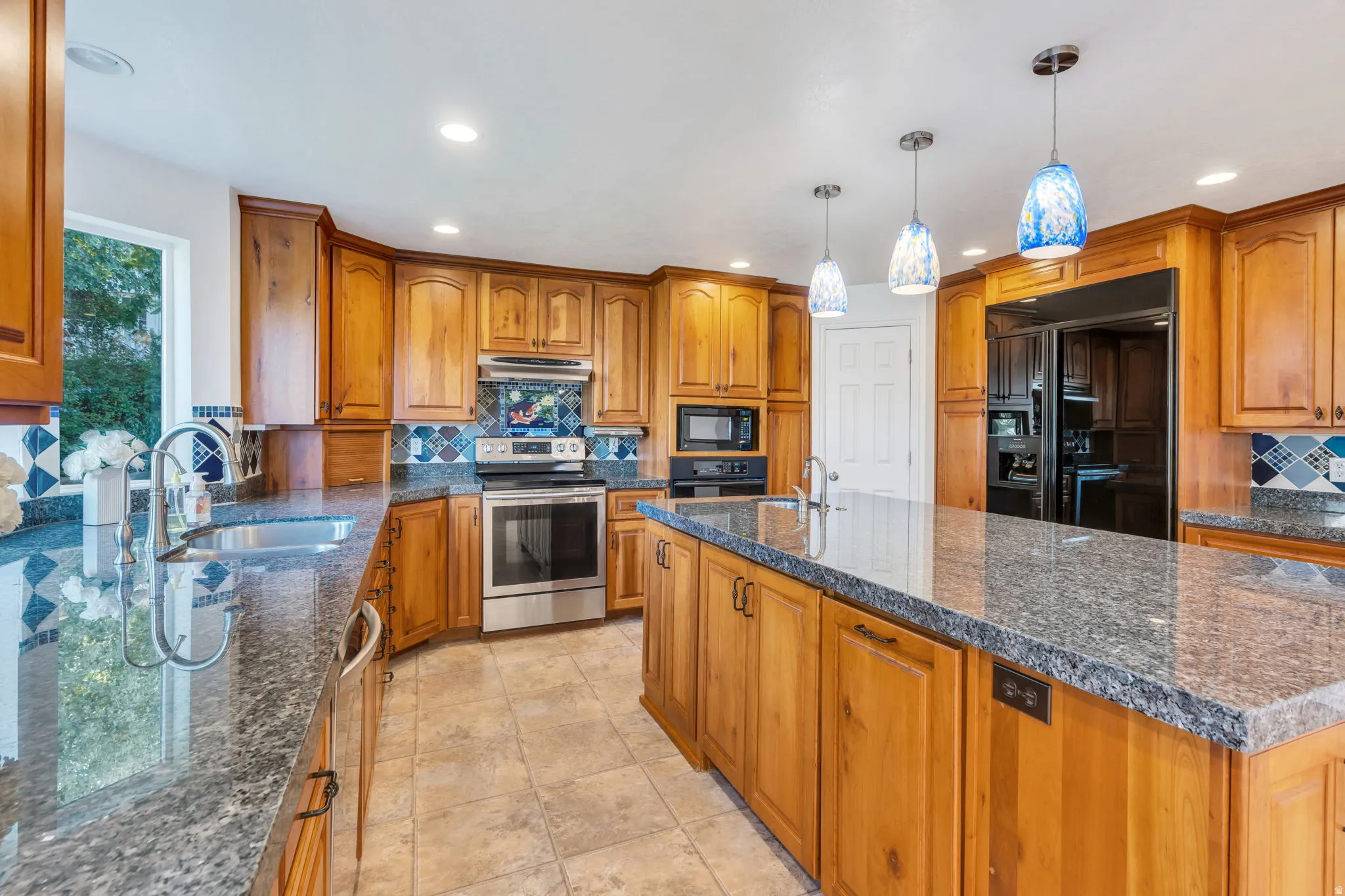 Kitchen featuring wood cabinetry, stainless steel appliances, a large center island, and recessed lighting