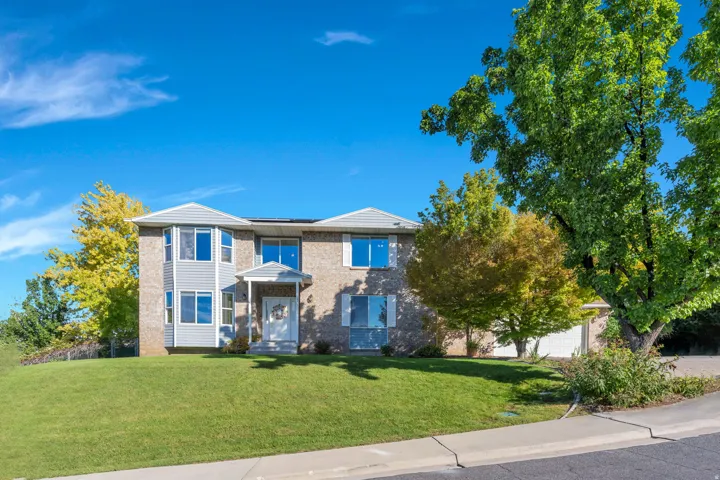 Two-story exterior with brick and siding, multiple bay windows, a covered entry, and an integrated garage
