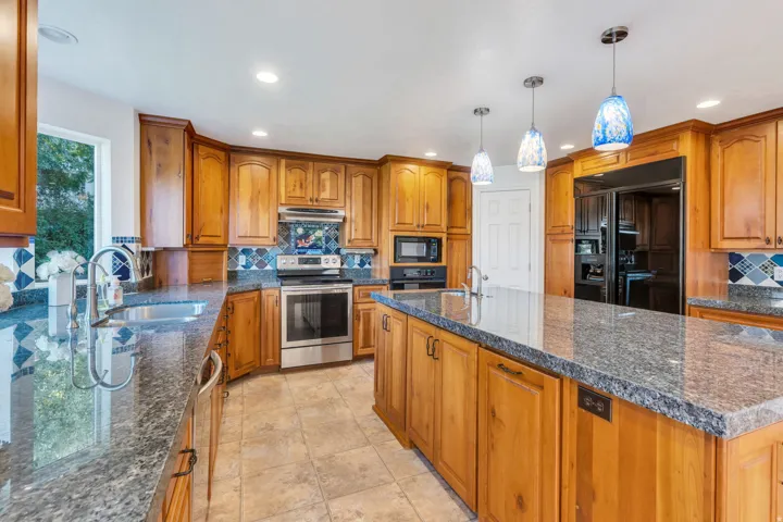 Kitchen featuring wood cabinetry, stainless steel appliances, a large center island, and recessed lighting