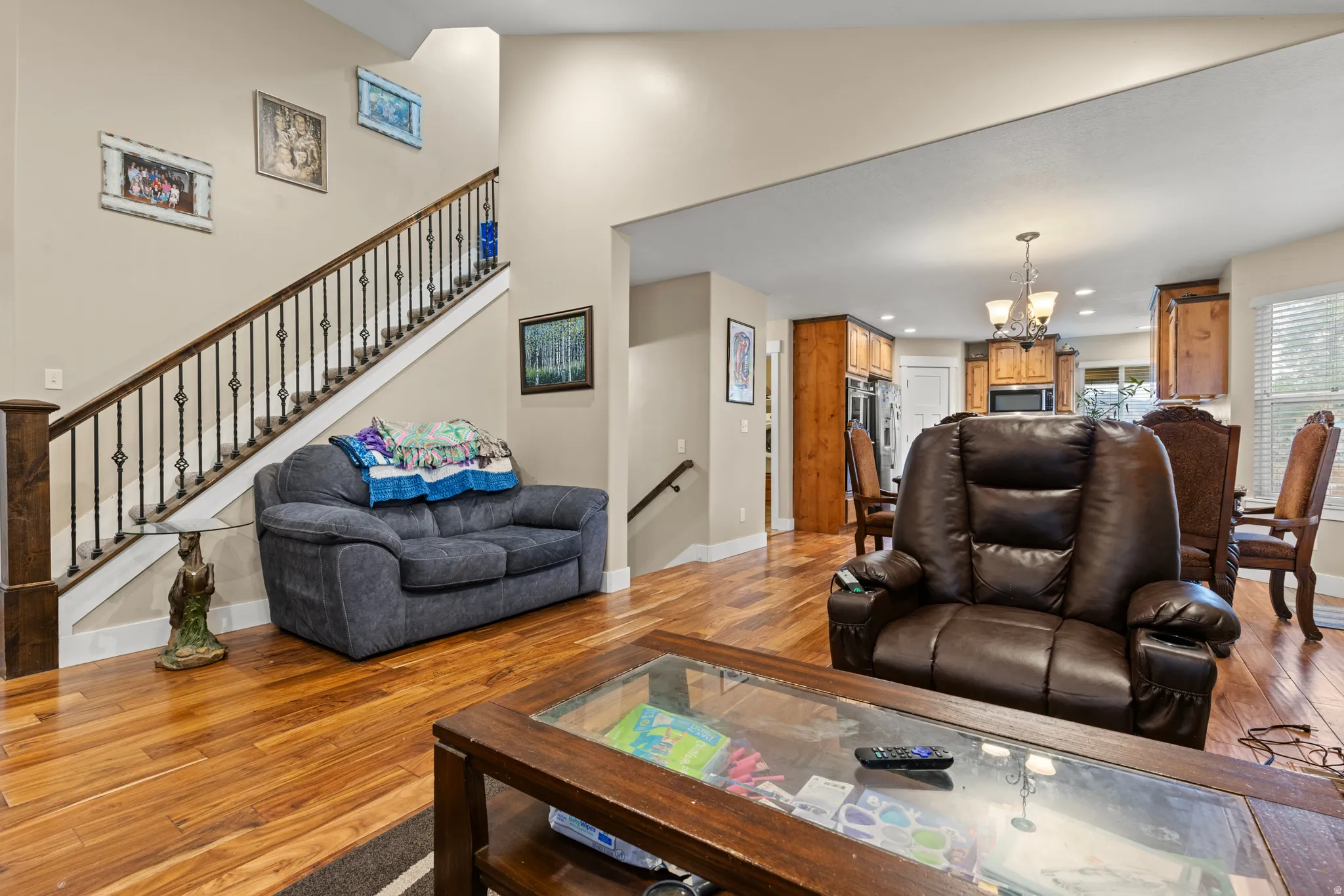 Hardwood flooring, high ceilings, open-concept design, staircase with decorative iron balusters, and recessed lighting