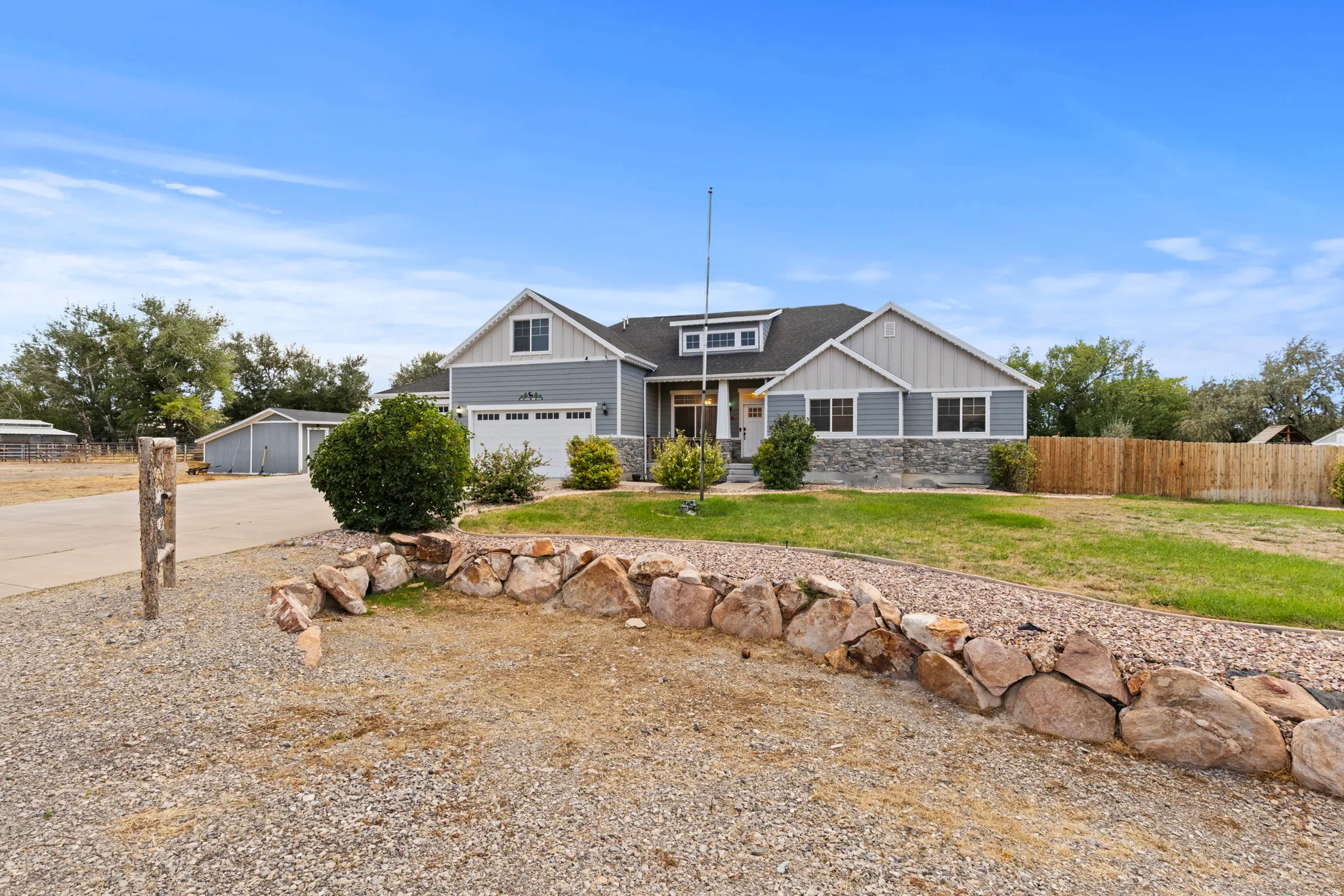 Craftsman-style home featuring a stone facade, horizontal siding, and a gabled roofline