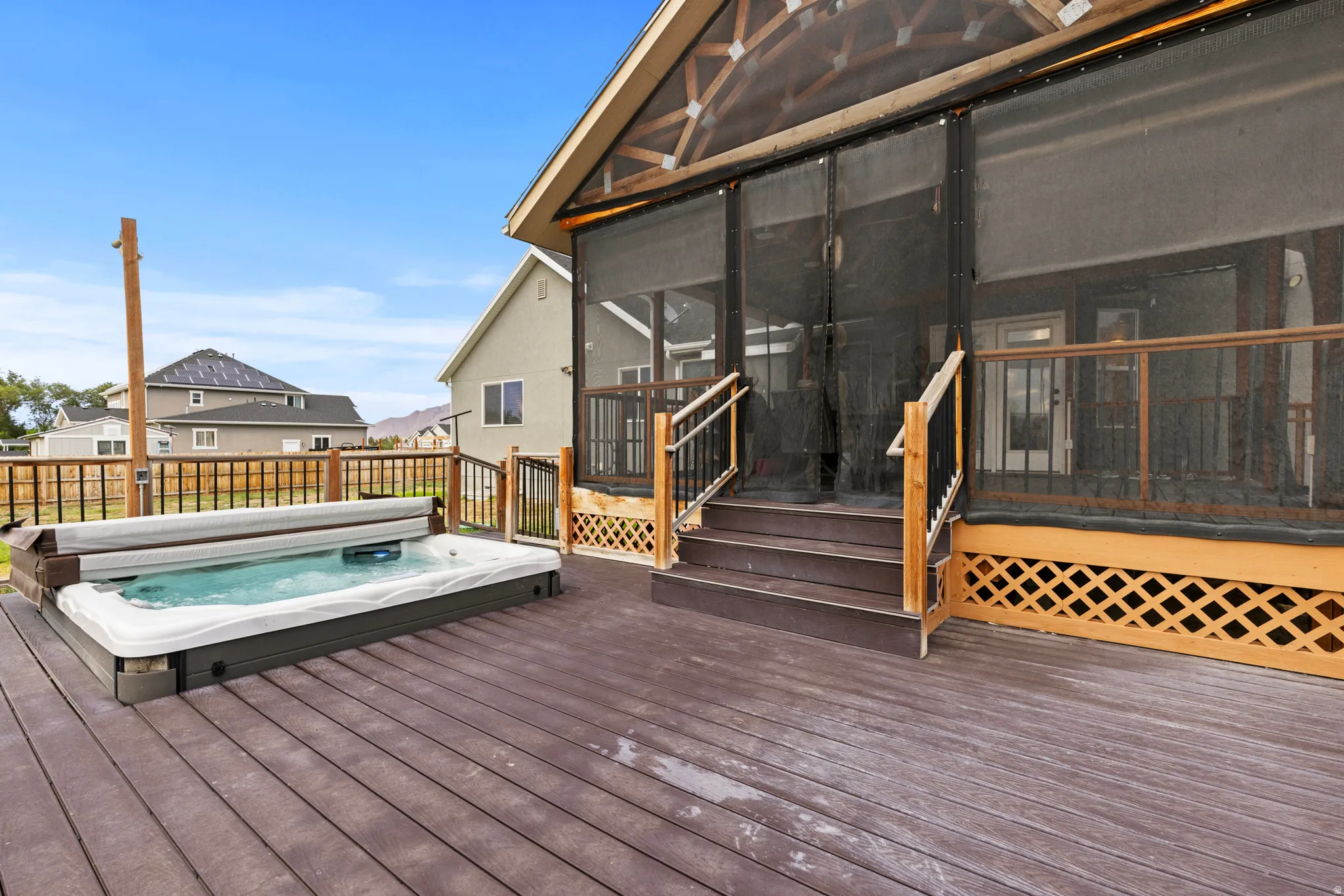 Expansive outdoor deck with a built-in hot tub, providing a private outdoor amenity