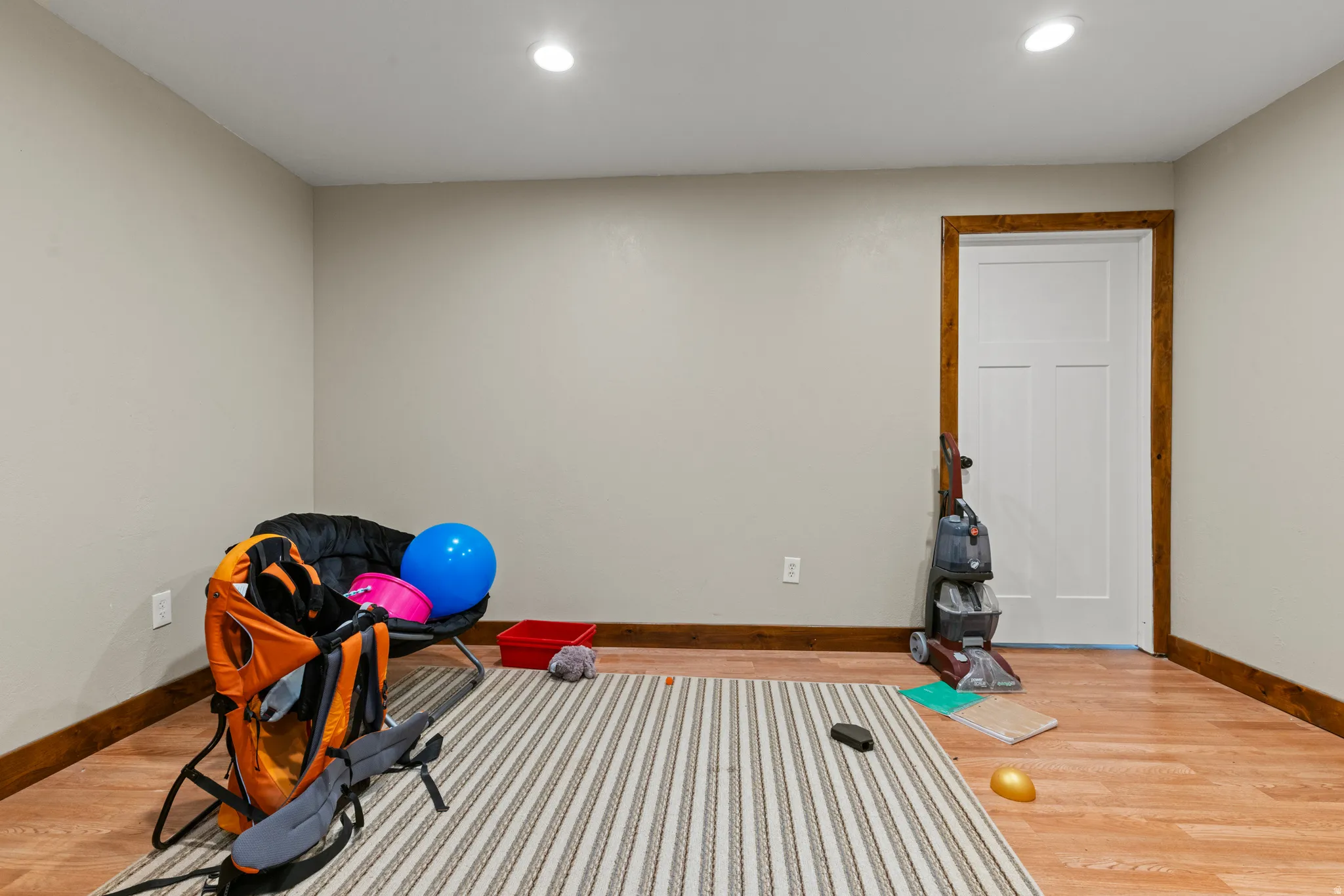 Recessed lighting, light-toned wall finishes, and wood-finish flooring with wood trim.  Can also be a storage room.
