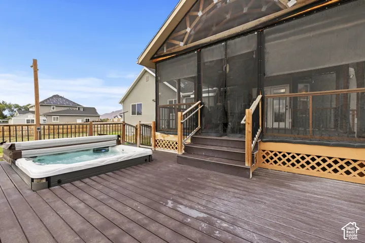Expansive outdoor deck with a built-in hot tub, providing a private outdoor amenity