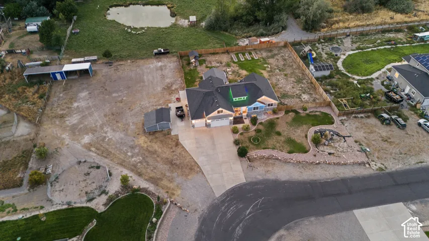 Residence with a dark shingle roof, attached garage, and a light-toned exterior