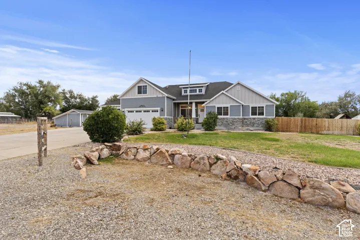 Craftsman-style home featuring a stone facade, horizontal siding, and a gabled roofline