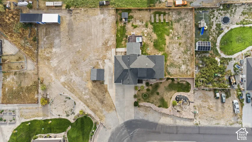 Expansive property featuring a large main residence, detached outbuilding, substantial paved driveway, and varied landscaping