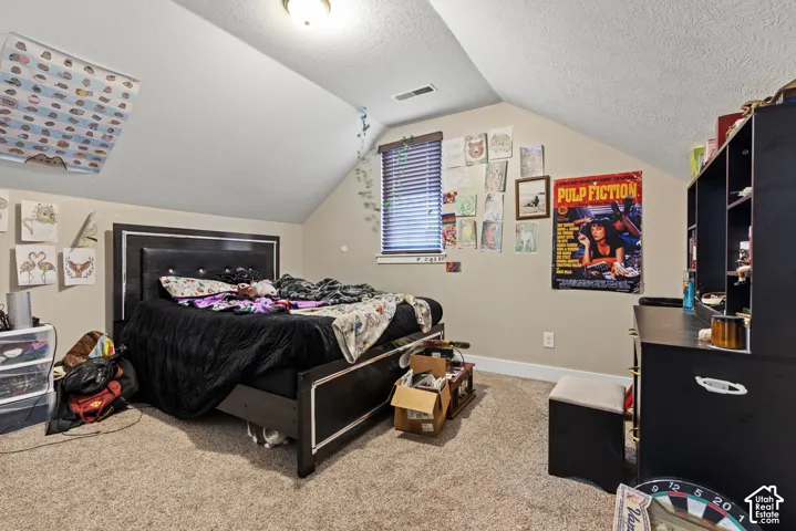 Sloped ceiling room featuring a window with blinds, recessed lighting, and carpeting