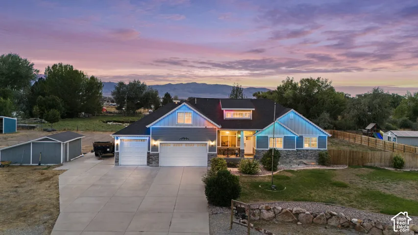 Contemporary residence featuring a two-car garage, stone accents, and a paved driveway