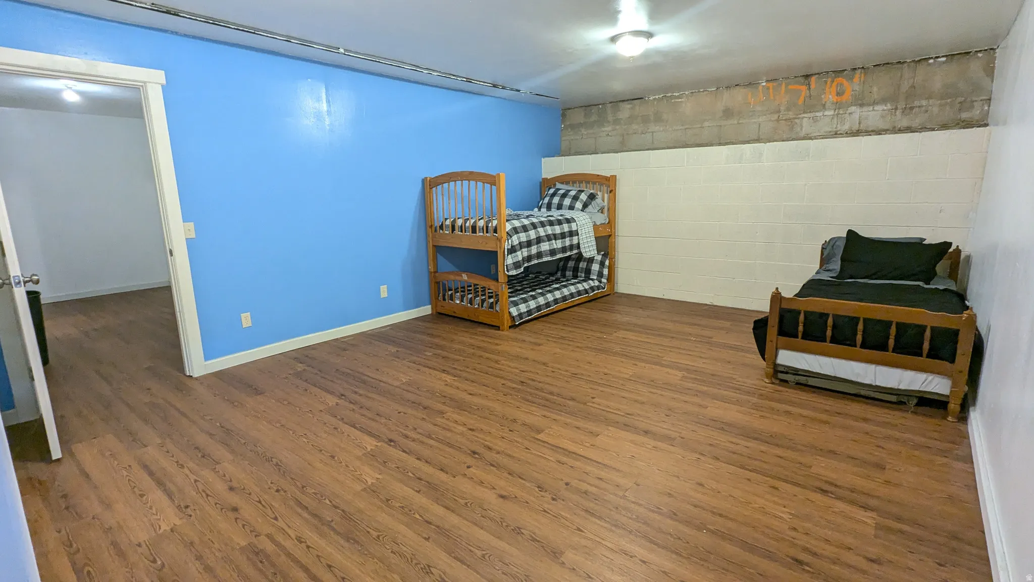 Spacious room featuring wood-finish flooring and a light blue accent wall