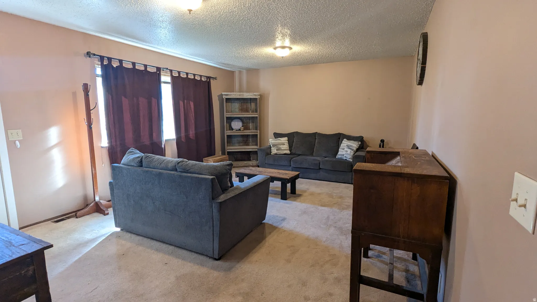 Neutral wall paint, textured ceiling, and recessed lighting