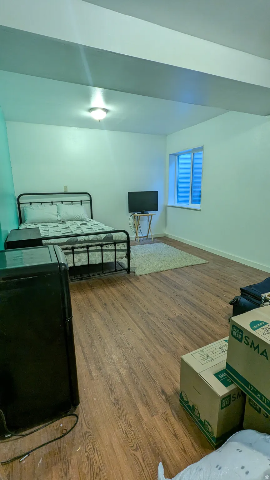 Wood-finish flooring throughout, white walls, and a recessed window