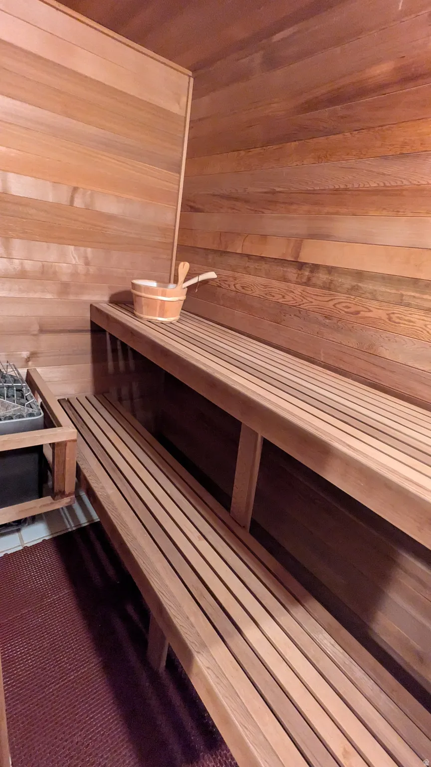 Cedar-lined sauna with tiered slatted benches and a built-in heating unit