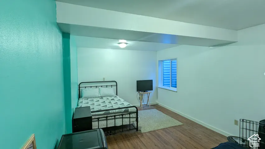 Recessed window with horizontal blinds, wood-finish flooring, and overhead flush-mount lighting