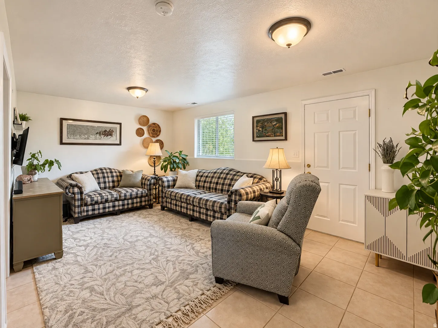 Recessed window with blinds, ceiling-mounted lighting fixtures, white paneled door, and neutral-toned wall paint