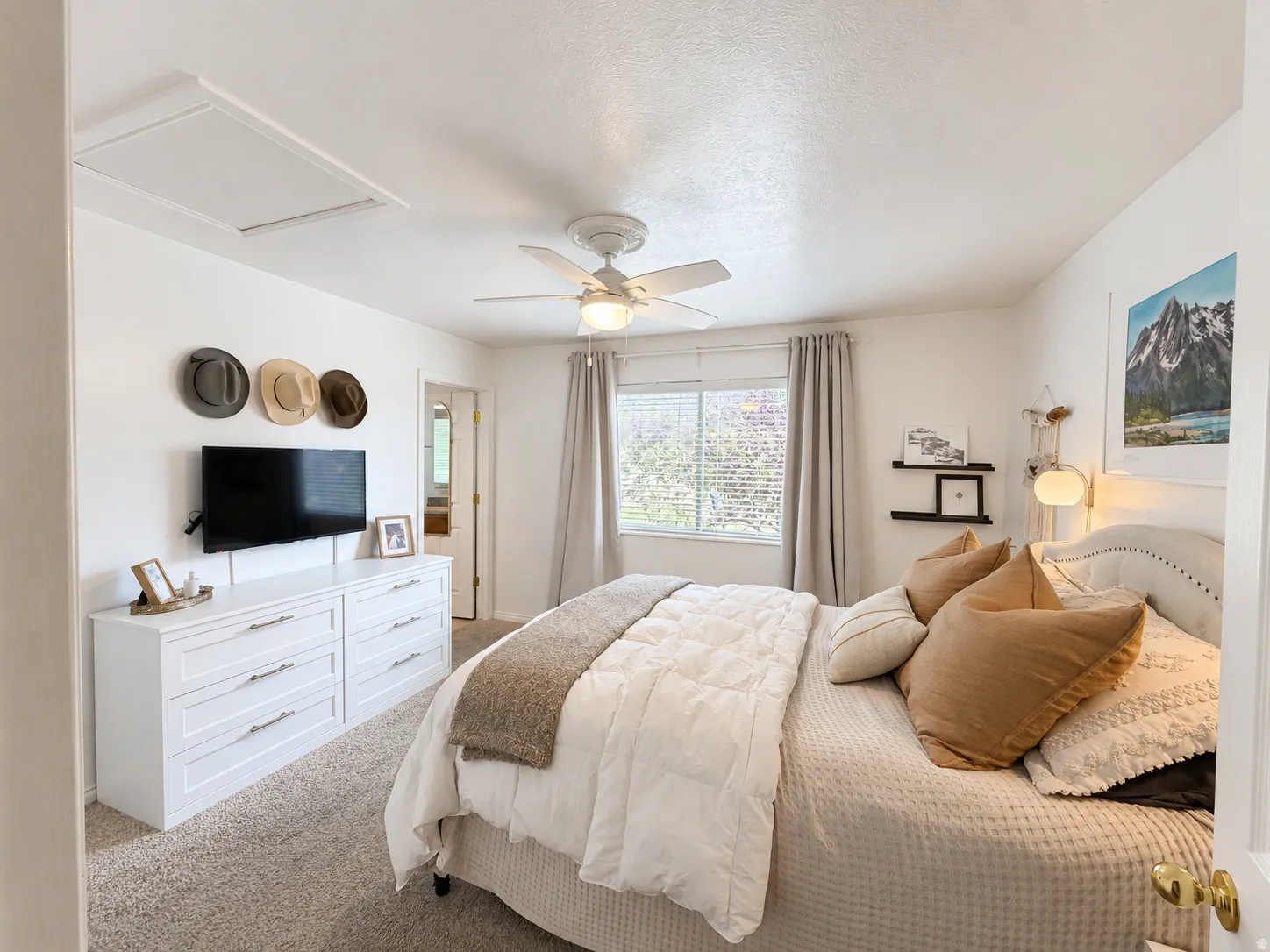 Recessed ceiling access panel, ceiling fan with integrated lighting, window with blinds and drapes, and a white framed doorway