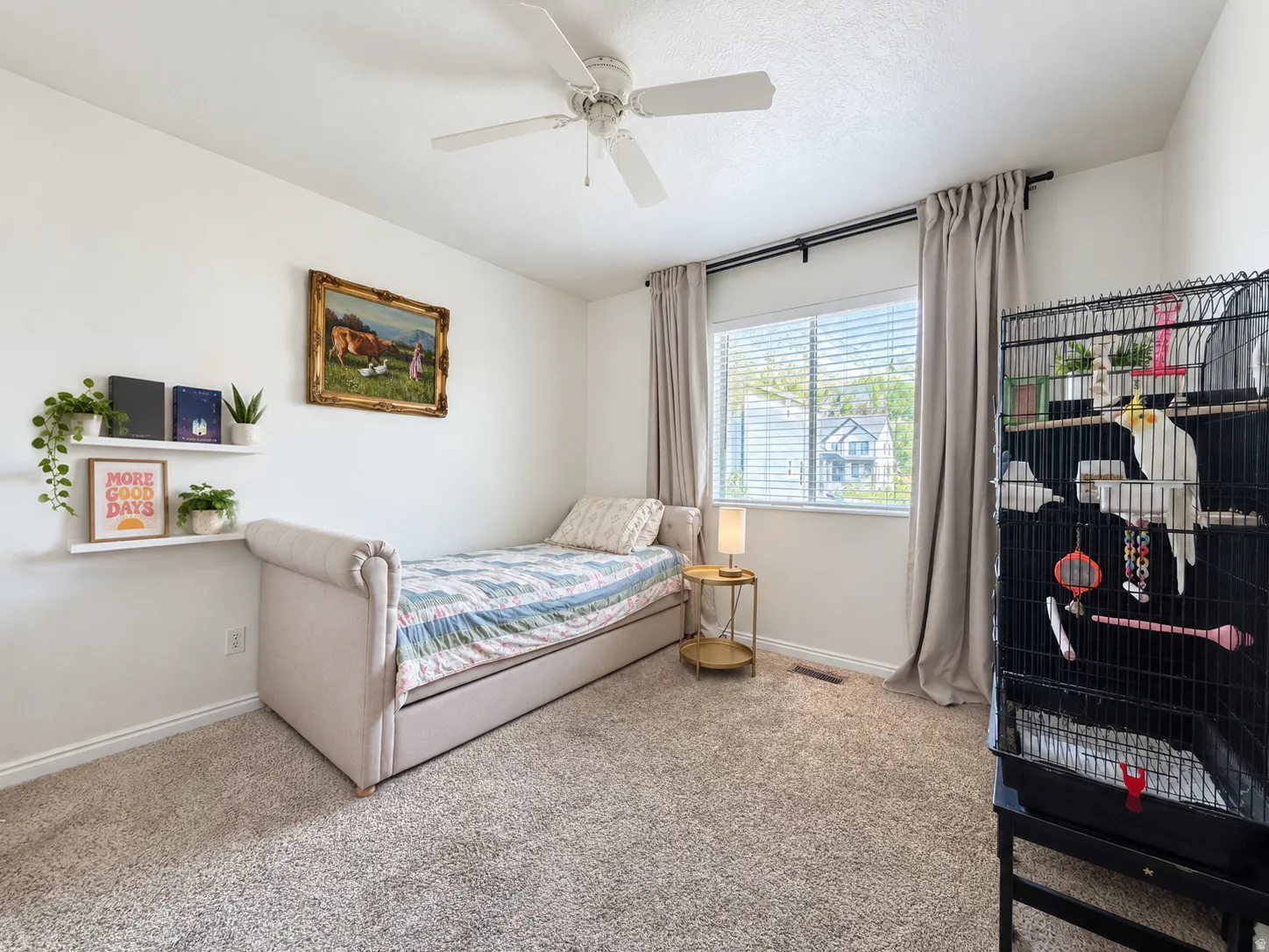 Neutral-toned carpeting paired with white walls, featuring a window with horizontal blinds and drapery, and an overhead ceiling fan