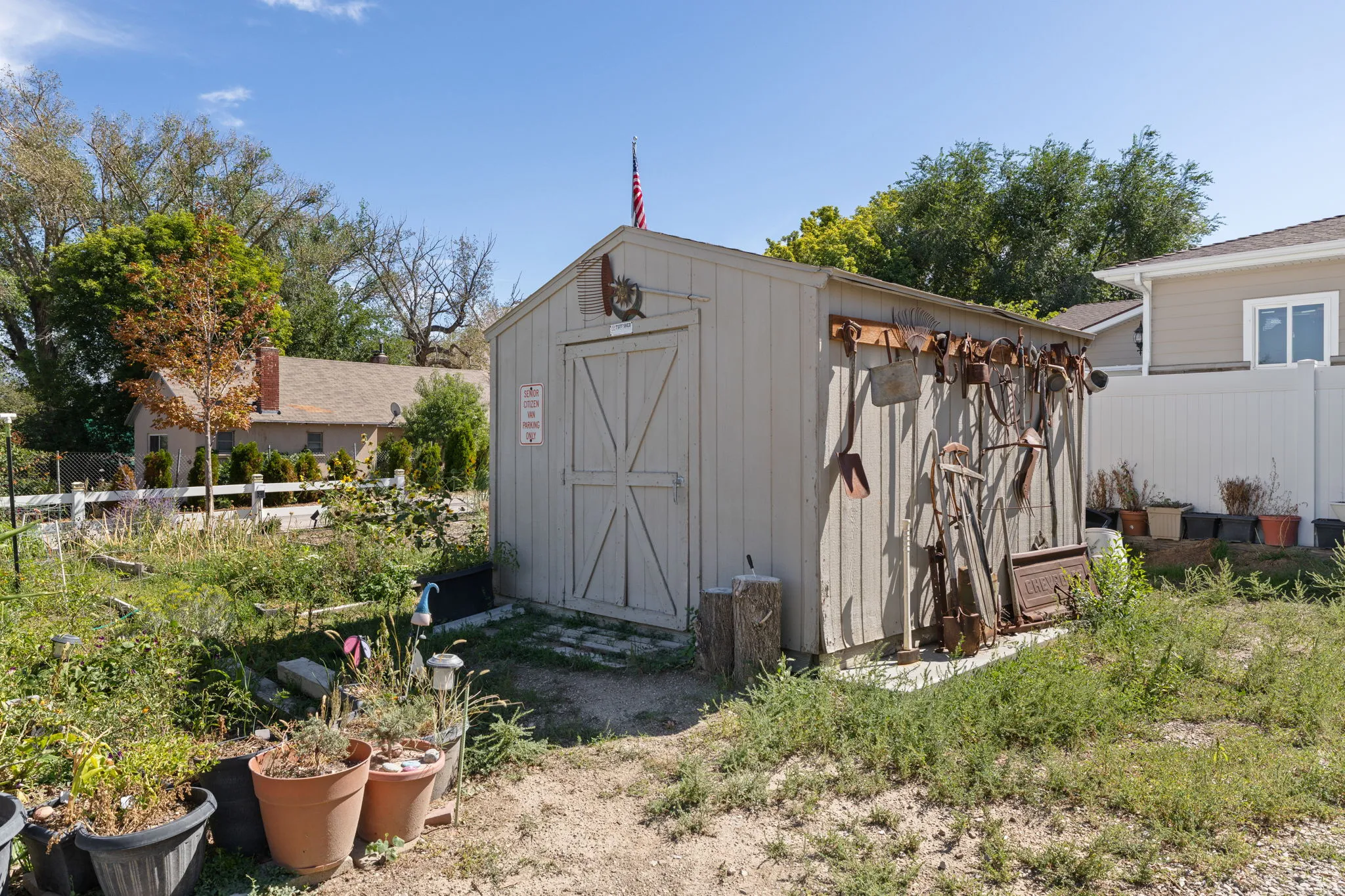 Detached utility shed featuring vertical panel siding and a double-door entry