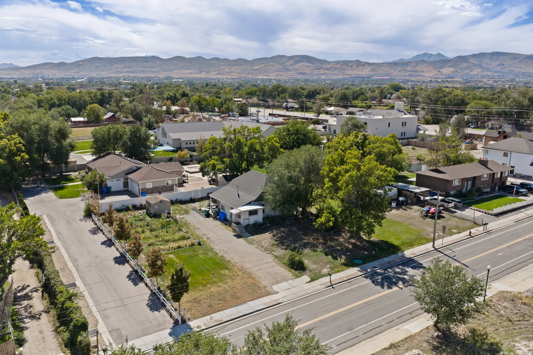 Expansive land parcel featuring direct street frontage, mature trees, and mountainous scenery