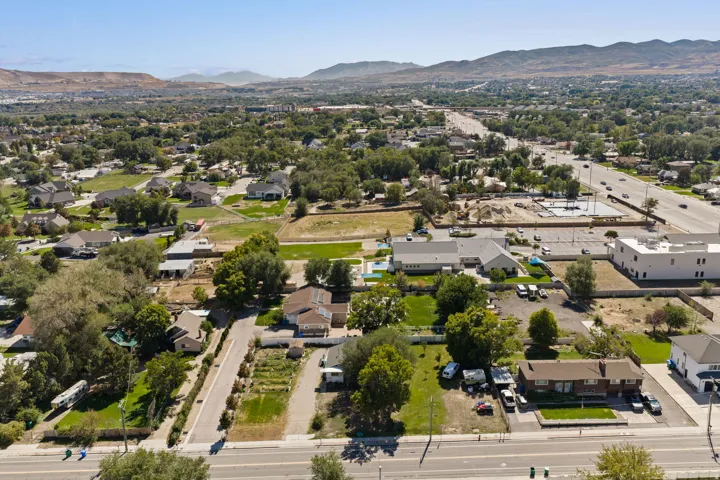Aerial view showcasing this property's expansive grounds with mature landscaping, manicured lawn areas, and direct street frontage